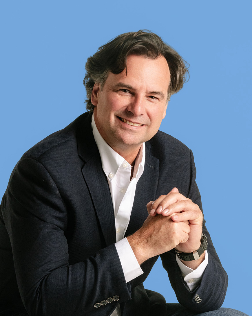 Retrato profesional de hombre con traje sobre fondo azul, estilo corporativo para LinkedIn